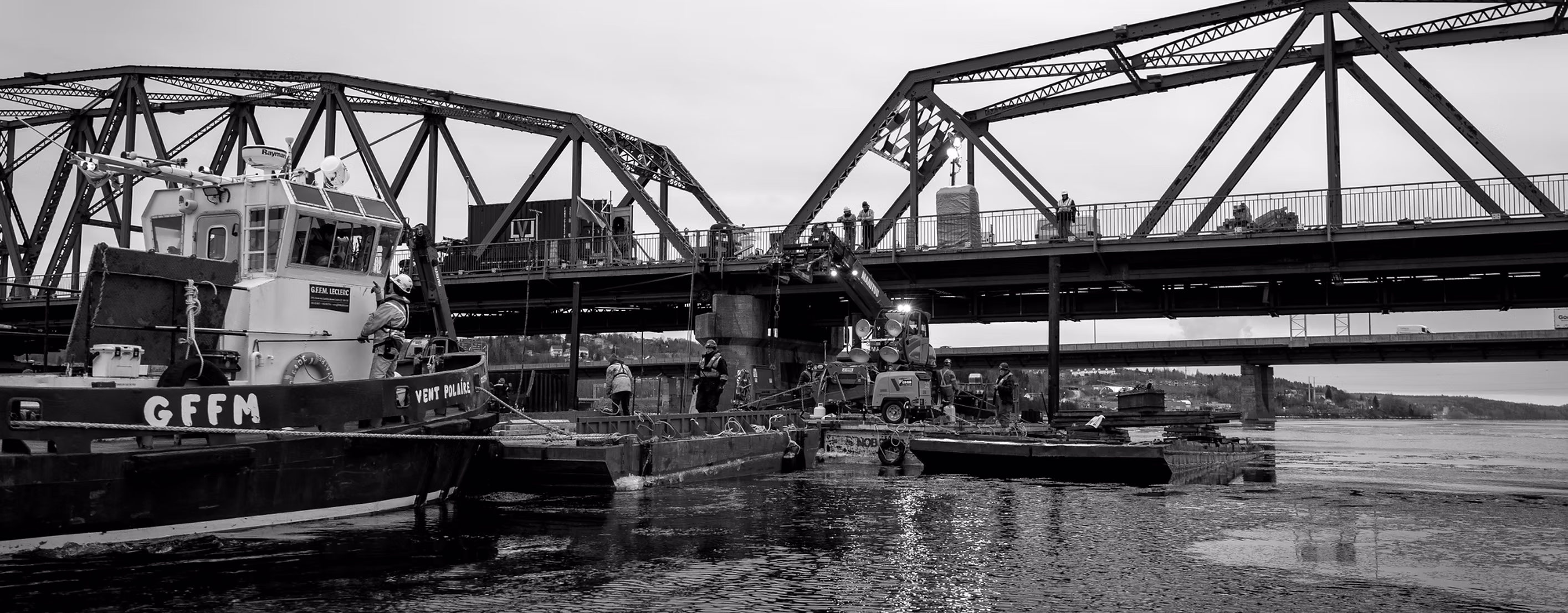 Nitrox Welding team on a barge at the foot of a steel bridge, marine job site